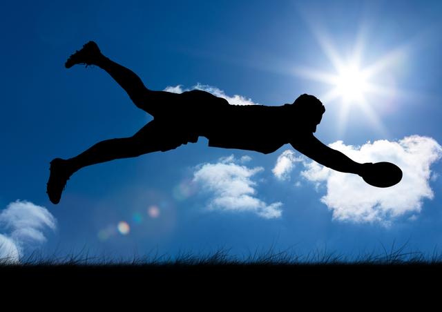 Silhouette of player catching rugby ball against sky in background - Download Free Stock Photos Pikwizard.com
