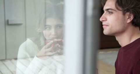 Romantic Couple Enjoying Warm Drinks on Cozy Balcony