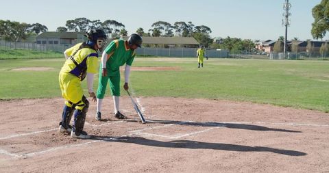 Batter Tapping Bat with Catcher at Home Plate on Sunny Suburban Baseball Field