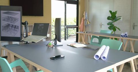 Modern architecture studio workspace showing collaborative meeting table with blueprints