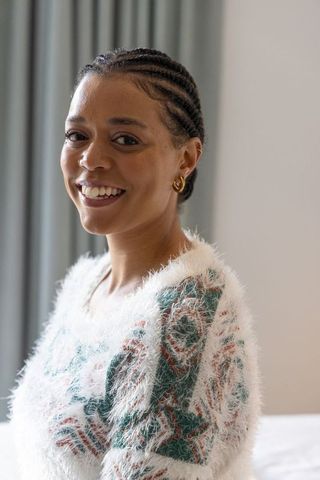 Warm portrait of african american woman smiling in fuzzy sweater with gold hoop earrings