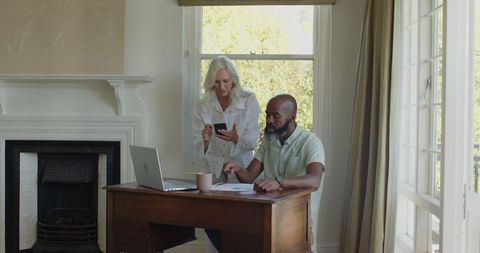 Mature Couple Planning Wedding with Technology at Home Office