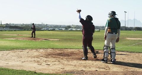 Baseball Players Pitching and Catching Under Clear Sky