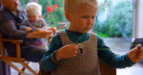 Young Boy Focused on String Crafting Project