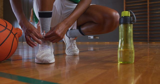 Athlete Tying Shoes on Indoor Basketball Court - Download Free Stock Photos Pikwizard.com