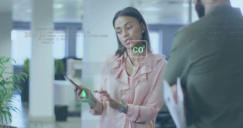 Woman presenting augmented reality co2 and water controls on mobile for office team
