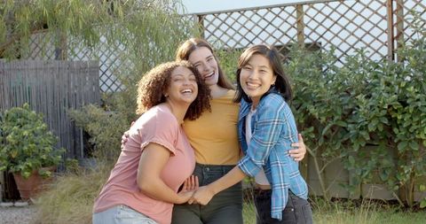 Three Friends Laughing Outdoors Together