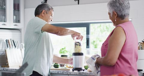Senior Couple Making Healthy Smoothie in Modern Kitchen