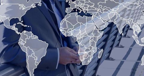 Businessman standing on rooftop terrace with world map overlay