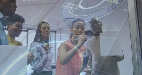 Team Collaborating on Glass Board for Innovative Solutions