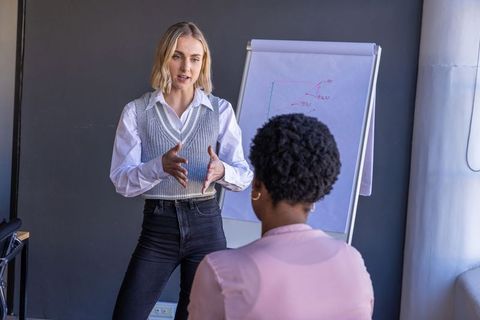 Diverse Female Professionals Analyzing Data on Flip Chart