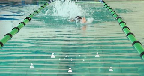 Swimmer performing front crawl in indoor lap pool