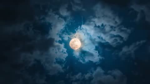 Full Moon Surrounded by Dynamic Clouds in Night Sky