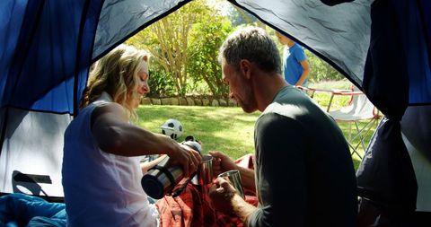 Couple Enjoying Morning Coffee in Camping Tent
