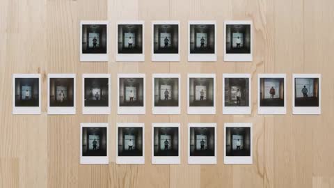 Overhead video arranging Polaroid portrait grid on light wood tabletop portfolio display