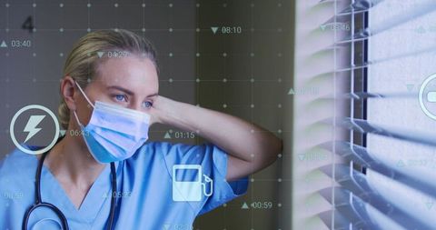 Nurse with technology overlays observing through blinds in medical facility