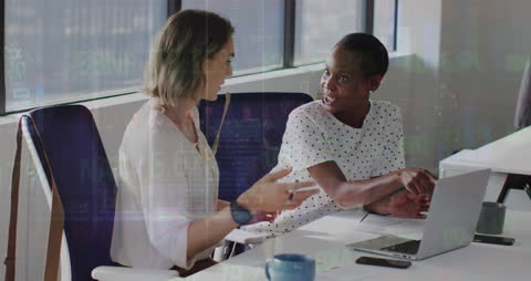 Diverse Female Coworkers Discussing Financial Data in Office