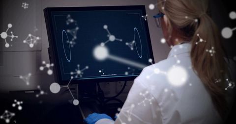 Laboratory researcher analyzing molecular data on workstation monitor with network overlay