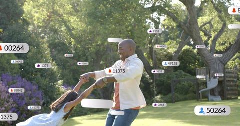 Spinning father and daughter playing in sunlit backyard with floating engagement badges