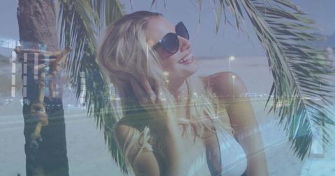 Smiling blonde woman wearing sunglasses on sunny beach with city roadway double exposure