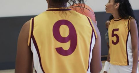 Diverse female basketball team in action at indoor gym