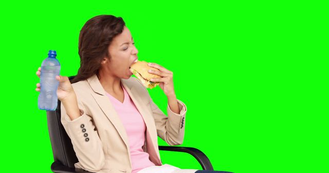 Businesswoman eating sandwich for lunch on green screen background