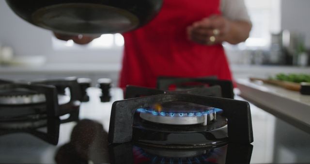 Person Cooking on Gas Stove in Modern Kitchen - Download Free Stock Images Pikwizard.com