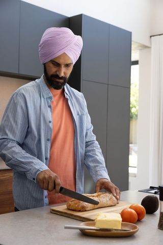 Man Preparing Fresh Artisan Bread at Modern Kitchen Island