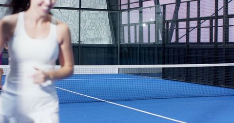 Energetic Female Athlete on Blue Padel Court