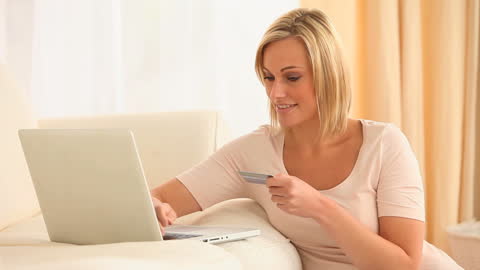Woman Smiling While Shopping Online with Laptop