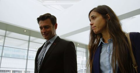 Businessman and Woman Engaging in Office Discussion with Copy Space