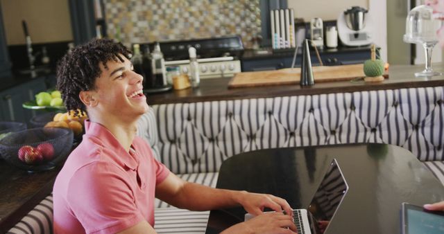 Young Man Laughing While Using Laptop in Modern Kitchen - Download Free Stock Images Pikwizard.com