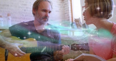 Father teaching guitar chords to daughter at home