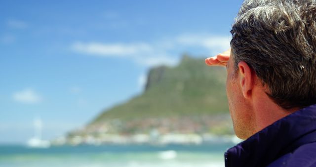 Man looking at mountains over sea with focus on back of head - Download Free Stock Images Pikwizard.com