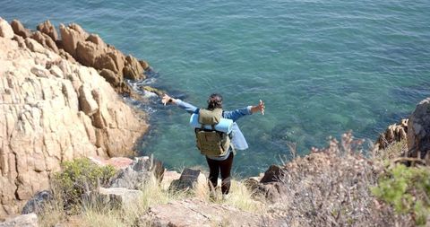 Adventurous Backpacker Overlooking Stunning Ocean Cliffs