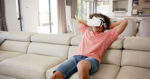 Man Relaxing on Sofa with Virtual Reality Headset in Modern Living Room