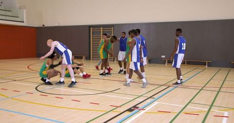 Diverse team practicing basketball with supportive team spirit