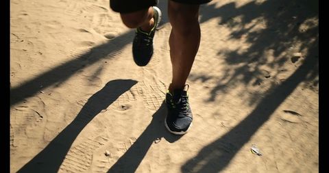 Young Male Runner Jogging on Sandy Path near Beach