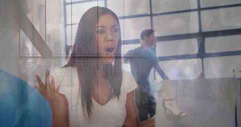 Surprised woman in office reacting to laptop screen, city skyline view