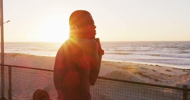 Person Walking by Beach at Sunset with Earphones - Download Free Stock Images Pikwizard.com