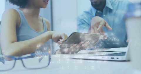 Two Professionals Collaborating with Technology in Modern Office