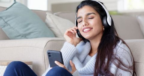 Young Woman Enjoying Music on Headphones at Home