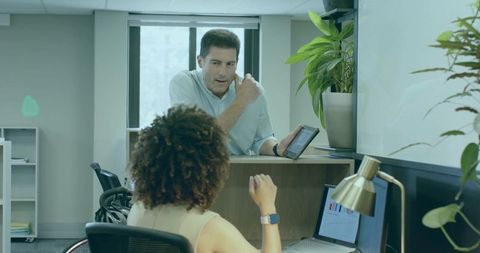 Man Assisting Woman in Wheelchair with Tablet at Office