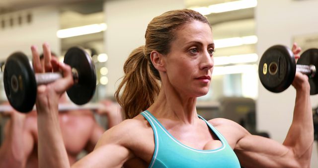 Focused Woman Lifting Dumbbells at Gym for Strength Training - Download Free Stock Images Pikwizard.com