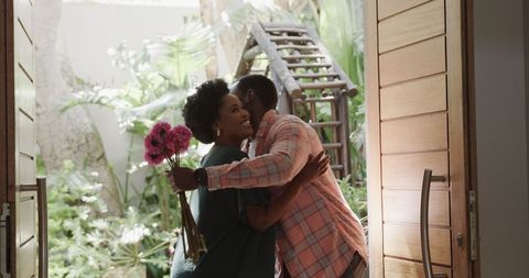 Romantic Couple Embracing at Home with Flowers