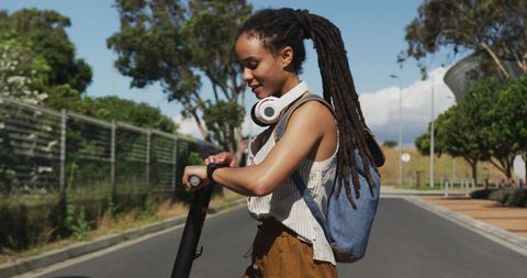 Digital Nomad Woman Navigating Urban Street on Electric Scooter