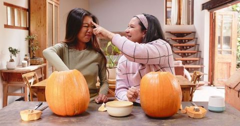 Multiracial family bonding over pumpkin carving for halloween