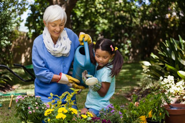Grandmother and granddaughter enjoying time together while watering plants in a backyard garden. Ideal for use in family-oriented advertisements, gardening blogs, and articles about multigenerational activities. Perfect for illustrating themes of bonding, nature, and outdoor activities.