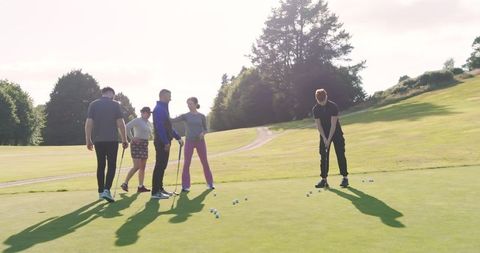 Group of Friends Putting on Sunny Golf Course Green