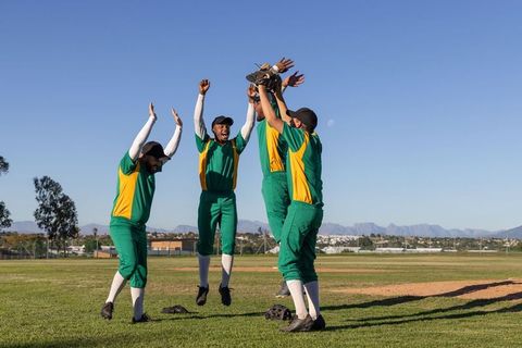 Baseball team celebrating by jumping after big catch with augmented stats overlay on glove